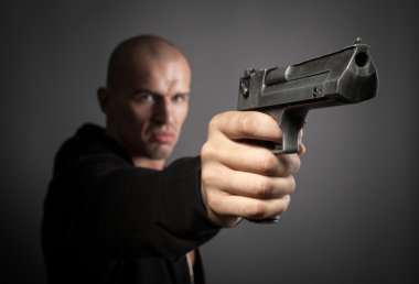 gri arka plan üzerinde izole ateş adam. silah üzerinde odaklanmak