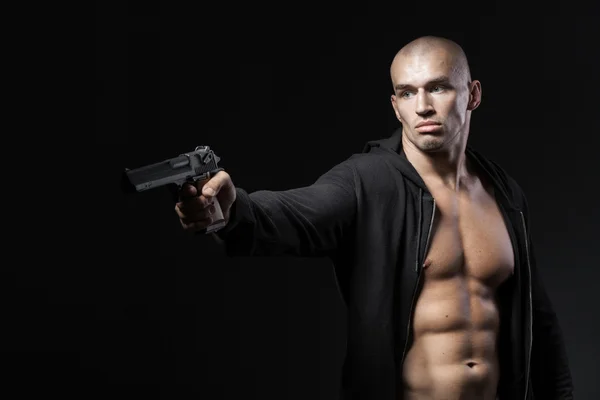 Mann schießt Waffe isoliert auf schwarzem Hintergrund — Stockfoto