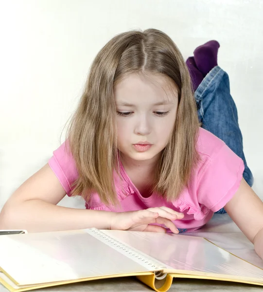 Das kleine Mädchen schaut sich ein Fotoalbum an — Stockfoto