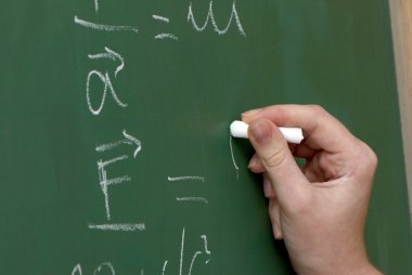 el ile bir tebeşir, bir tahta üzerinde matematiksel formüller