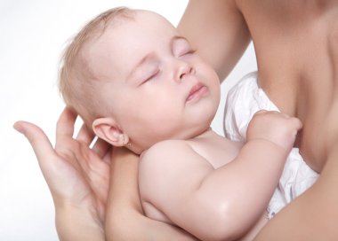 Bebek annenin elleri üzerinde uyuyor