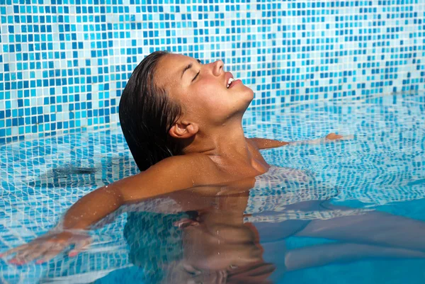 Menina feliz relaxante na piscina — Fotografia de Stock