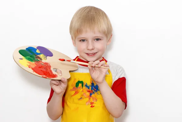 Kleine jongen met brush en kunstenaar palet met meerdere kleuren — Stockfoto