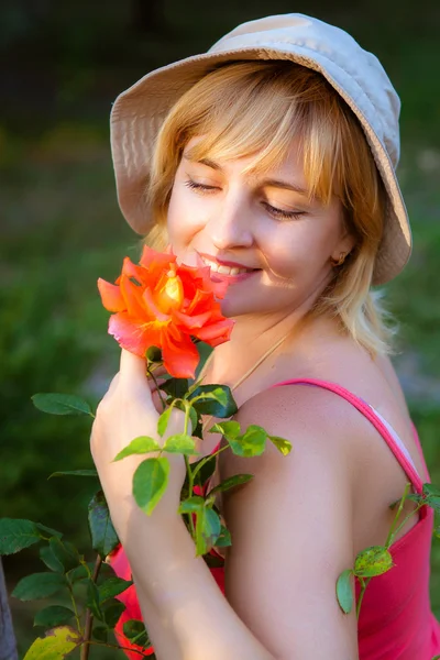 Žena dělat práci na zahradě čichání na růže — Stock fotografie