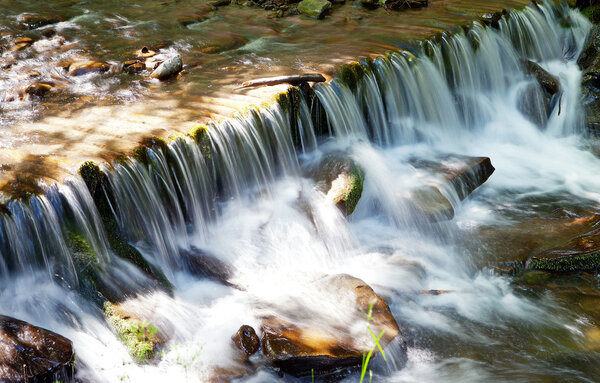 Водопад с деревьями и скалами в горах
