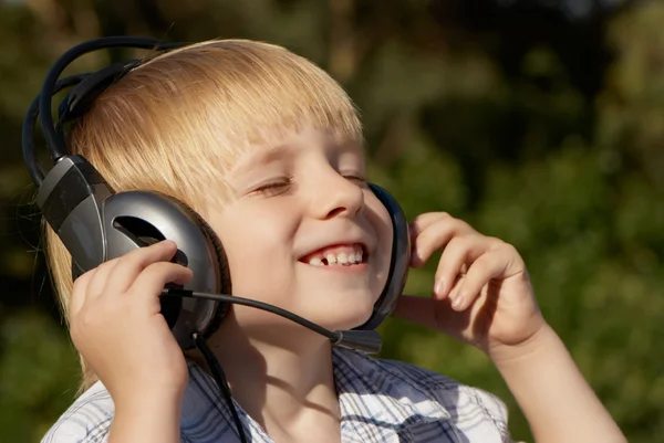 Niño relajado escuchando música en el parque —  Fotos de Stock