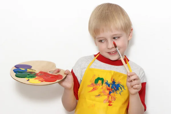 Liten pojke med borste och konstnärens palett med flera färger — Stockfoto