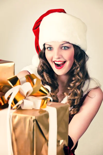 赤いドレスと大きな贈り物サンタの帽子で美しい女性 — ストック写真