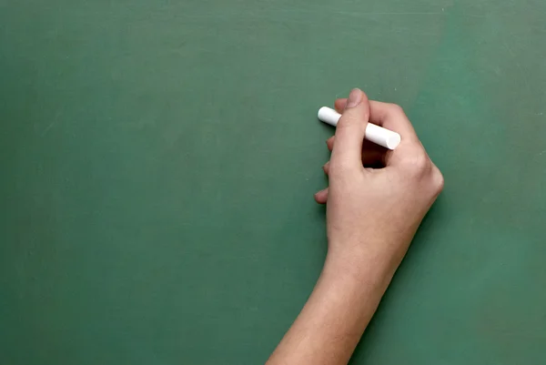 Un hombre sostiene un trozo de tiza, como si estuviera listo para escribir en una tiza — Foto de Stock