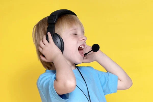 黄色の背景に耳電話で感情的な子供 — ストック写真