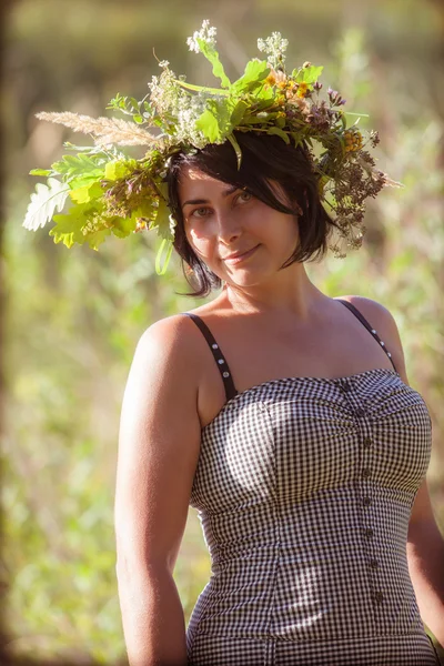 A imagem de uma menina vestindo uma coroa de flores silvestres no fiel — Fotografia de Stock