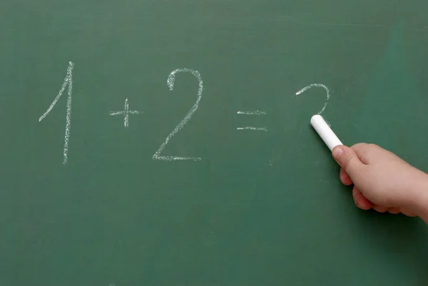 Hand met een krijt, wiskundige formules op een bord — Stockfoto