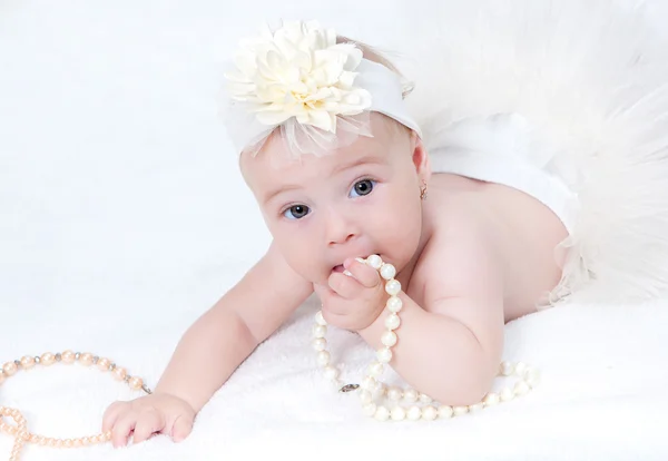 Portret pasgeboren baby liggend in bed met een parel ketting — Stockfoto