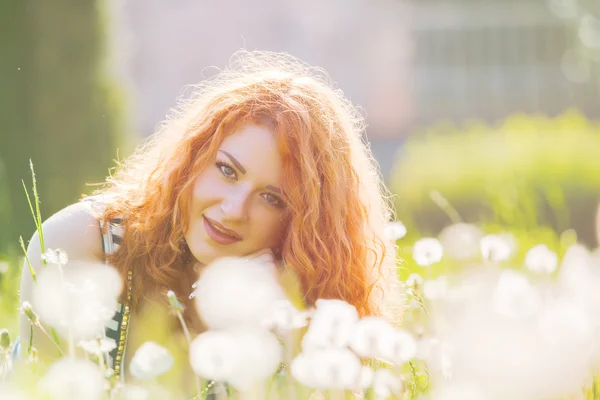 Счастливая молодая женщина в парке теплым летним днем — стоковое фото