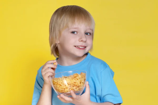 The nice boy with a bowl of corn-flakes — Stock Photo, Image