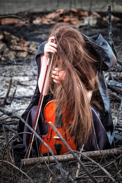 La chica pelirroja con un violín sentado sobre las cenizas —  Fotos de Stock