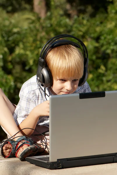 O menino com laptop no parque — Fotografia de Stock