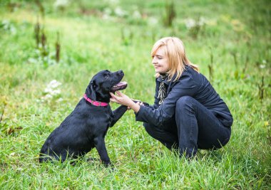 Kadın köpekle oynuyor.