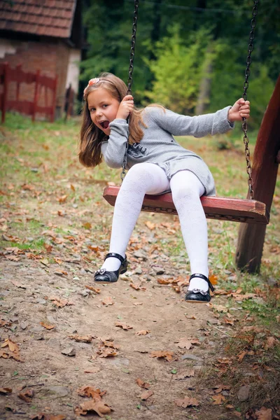 Flickan ler på svingen — Stockfoto