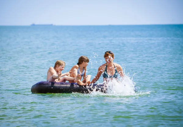 Familia en cama de aire en el mar — Foto de Stock