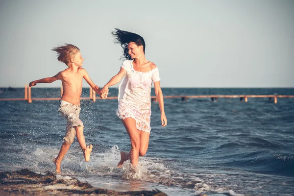 Mor och son på stranden — Stockfoto