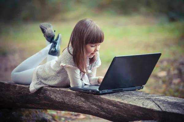 Barn i parken med laptop — Stockfoto