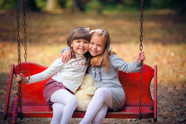 Vriendinnen op schommel in park — Stockfoto