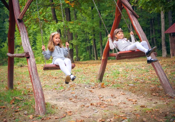 Vriendinnen op schommel in park — Stockfoto