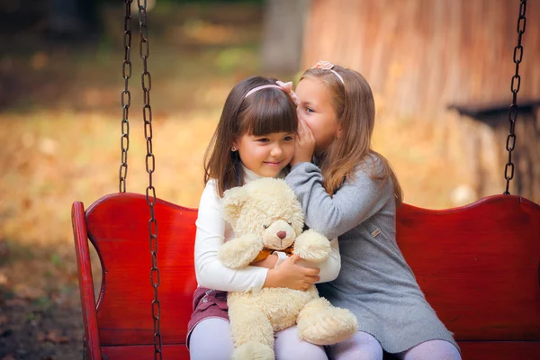 Girlfriends on swing in park — Stock Photo, Image