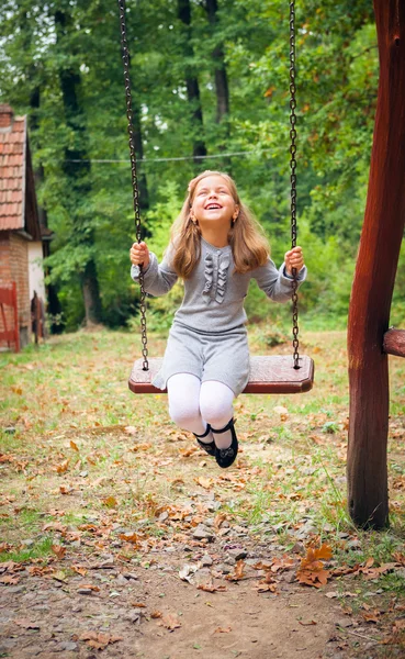 Meisje glimlachen op schommel — Stockfoto