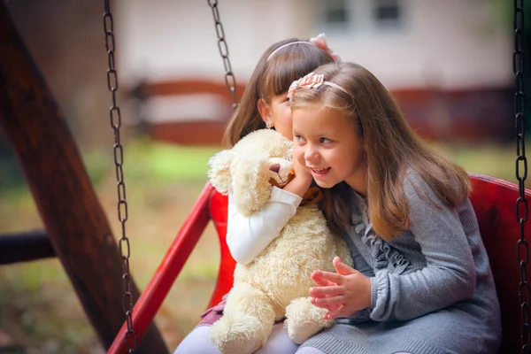 Girlfriends on swing in park — Stock Photo, Image