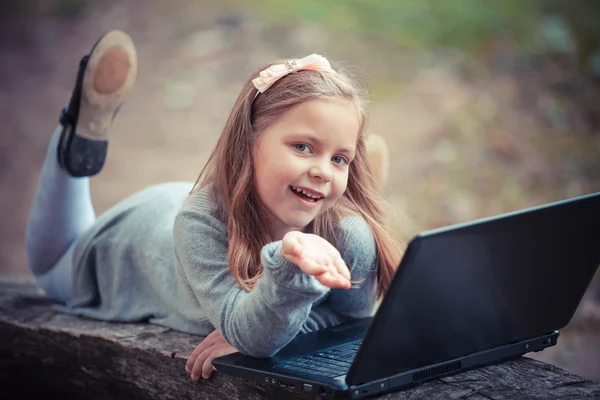 Bambino in parco con computer portatile — Foto Stock