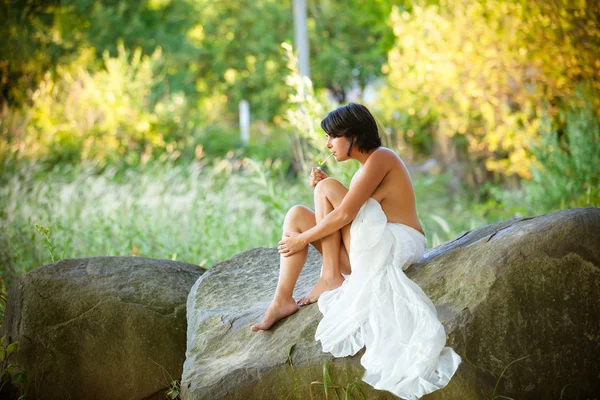 Woman sitting on  stone — Stock Photo, Image