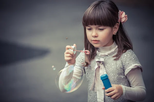 Liten flicka blåser bubblor — Stockfoto