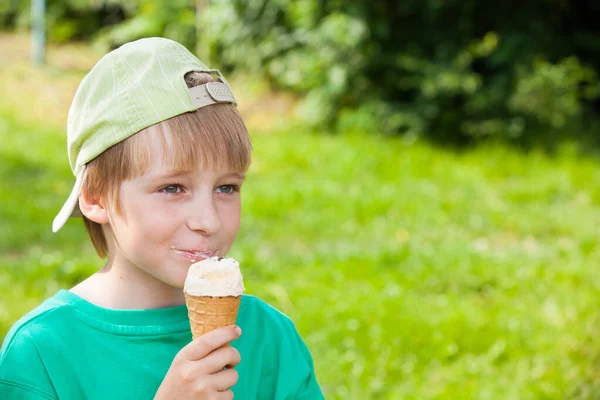 屋外の公園でアイスクリームを食べる男の子 — ストック写真