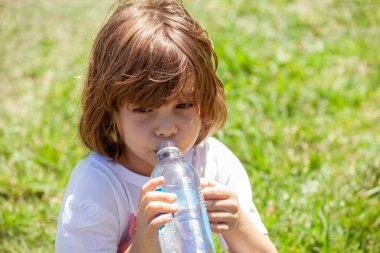 Parktaki şişeden su içen kız.