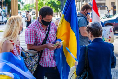 6 Mart 2022 Buenos Aires Arjantin: Rus saldırısı sırasında Ukrayna 'ya destek yürüyüşü yapan bayrak satıcısı