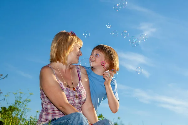 Mor Och Son Blåser Bubblor Utomhus — Stockfoto