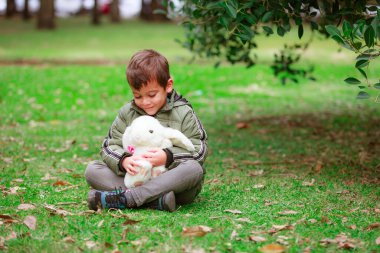 Parkta oyuncak tavşanı olan İspanyol çocuk.