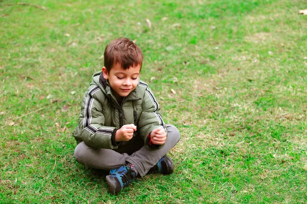 公園の草の上に座っているヒスパニック系の少年 — ストック写真