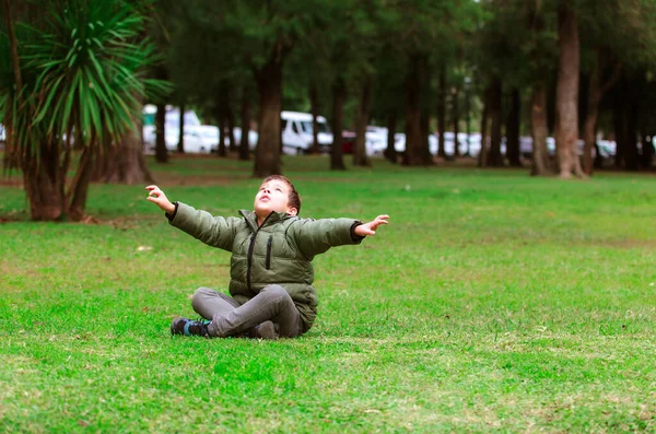Parktaki Çimlerin Üzerinde Oturan Spanyol Çocuk — Stok fotoğraf