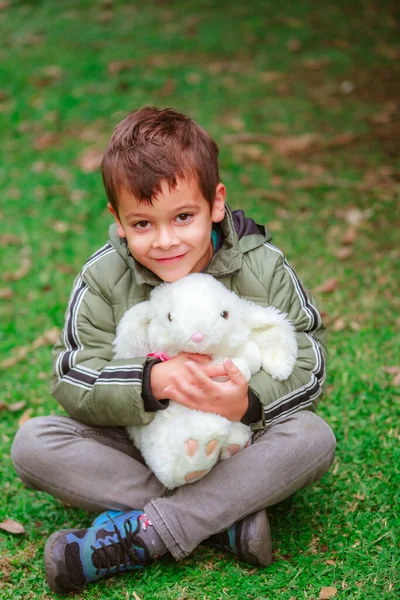 ヒスパニック系の男の子とともにおもちゃのウサギで公園 — ストック写真
