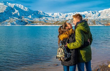 Karlı dağların arkasında mutlu genç bir çift