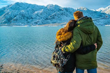 Karlı dağların arkasında mutlu genç bir çift