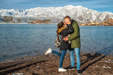 Karlı dağların arkasında mutlu genç bir çift