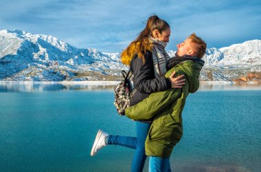 Karlı dağların arkasında mutlu genç bir çift
