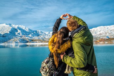 Karlı dağların arkasında mutlu genç bir çift