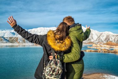 Karlı dağların arkasında mutlu genç bir çift