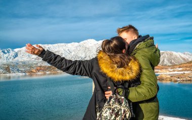 Karlı dağların arkasında mutlu genç bir çift
