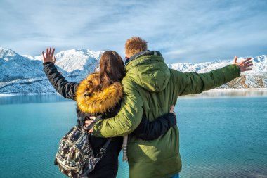Karlı dağların arkasında mutlu genç bir çift